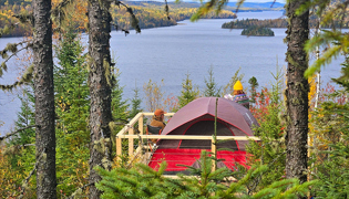 Un site pour camper au sommet d’une montagne avec vue sur un lac